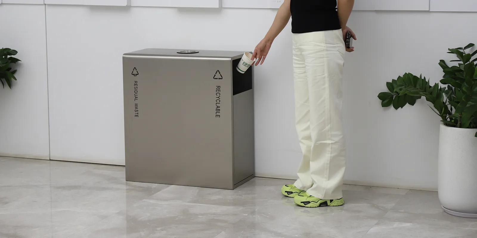 Person using the side opening of a shared office recycling station